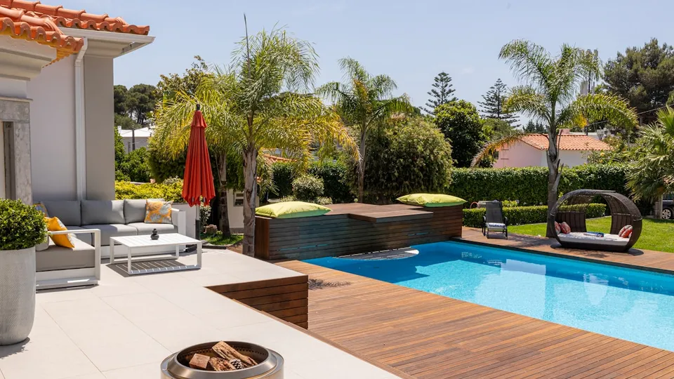 Piscine résidentielle avec terrasse en bois et salon de jardin