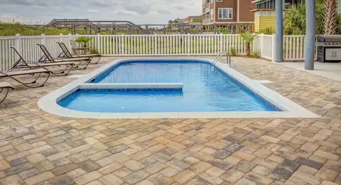 Flacon de produit d'hivernage versé dans une piscine